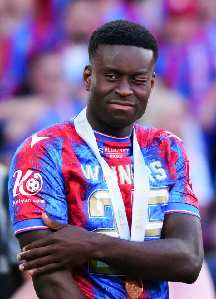 Marc Guéhi of Crystal Palace with an eye injury, wearing a winner's medal.
