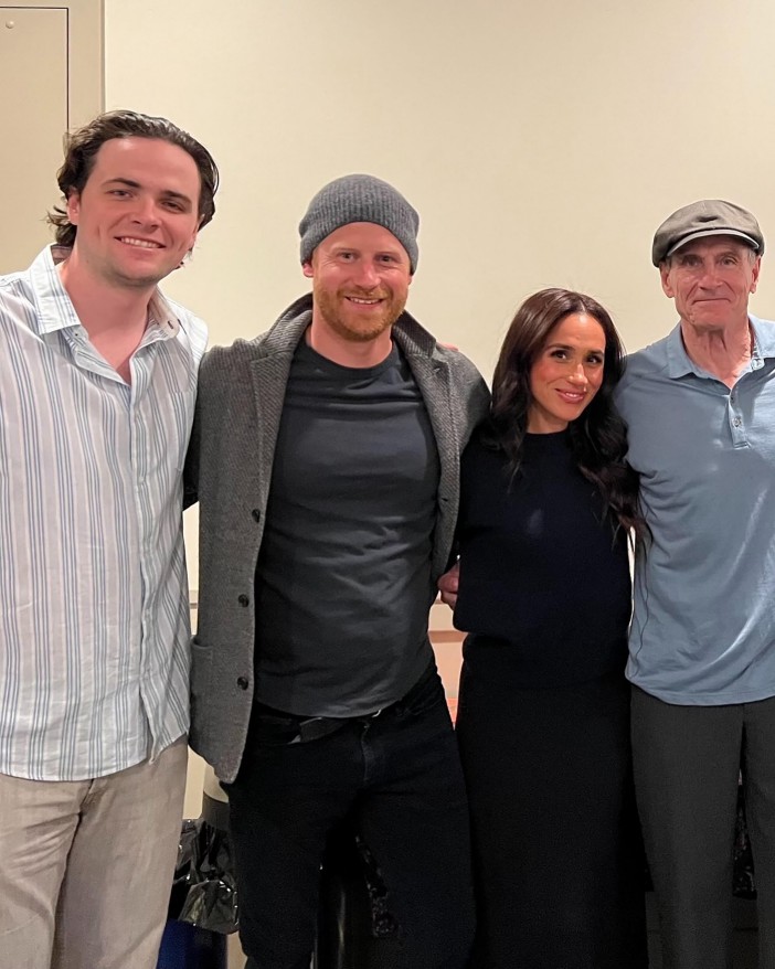 Prince Harry and Meghan Markle with two other people at a concert.