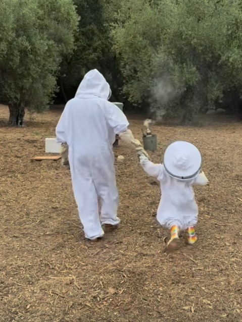 Meghan Markle and Lilibet wearing beekeeping suits.
