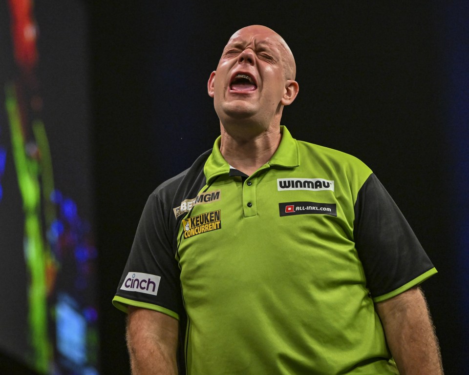 Michael van Gerwen grimacing during a darts match.