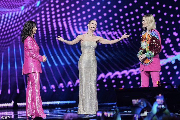Eurovision host Michelle Hunziker (C), 48, looked incredible in a glitzy silver gown as she graced the stage alongside Sandra Studer, 56, (L) and Hazel Brugger, 31, (R) on Saturday
