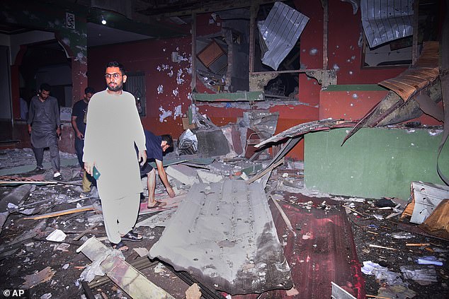 Local residents examine a building damaged from a suspected Indian missile attack near Muzaffarabad, the capital of Pakistan controlled Kashmir, in Wednesday, May 7, 2025