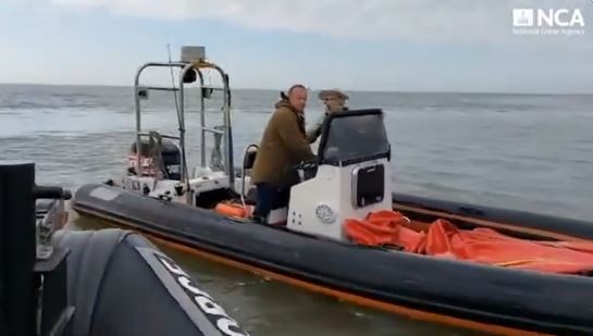 Two men on a rigid-hulled inflatable boat after a cocaine seizure.