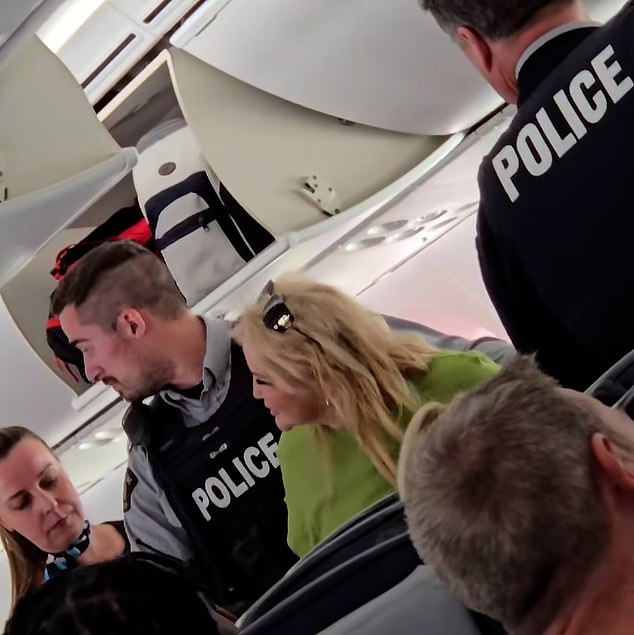 The mother being removed by the cop begins shouting down the plane to her daughter