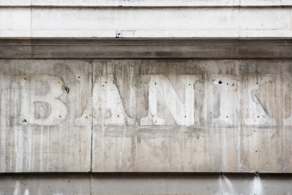 Faded "BANK" sign on a weathered building.