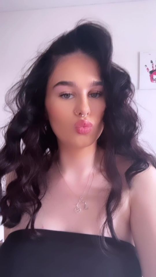 Portrait of a young woman with long, dark curly hair.