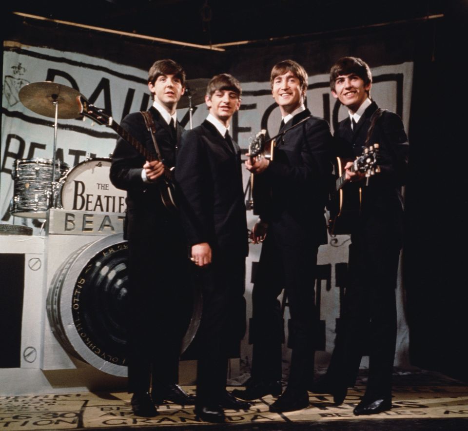 The Beatles performing on a television show in front of a camera-shaped drum kit.