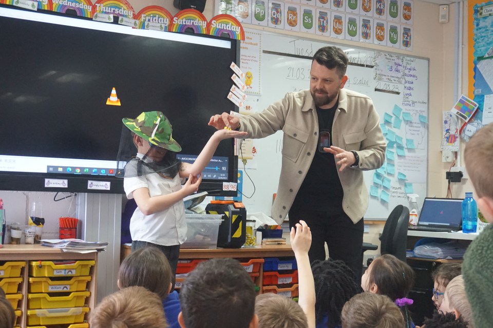 A man presenting to a classroom of children.
