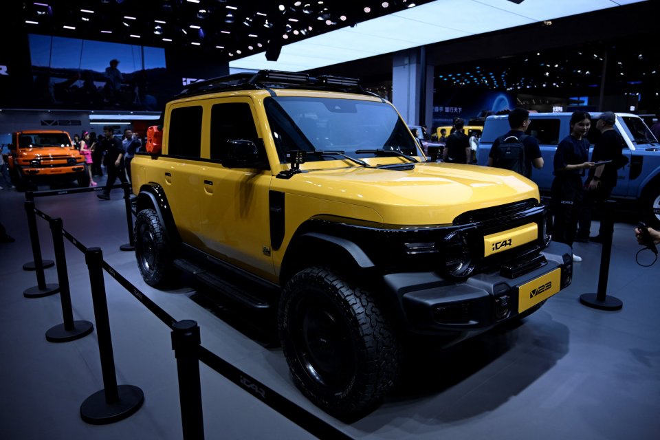 Yellow ICAR V23 vehicle on display at an auto show.