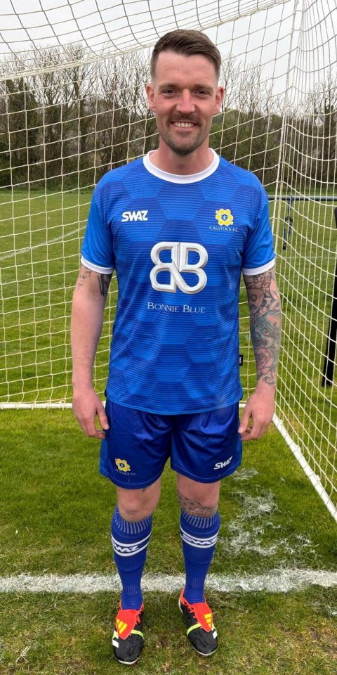 A soccer player in a blue Calstock F.C. jersey sponsored by Bonnie Blue.