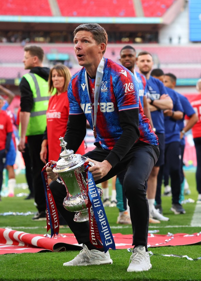 Crystal Palace manager holding the Emirates FA Cup trophy.