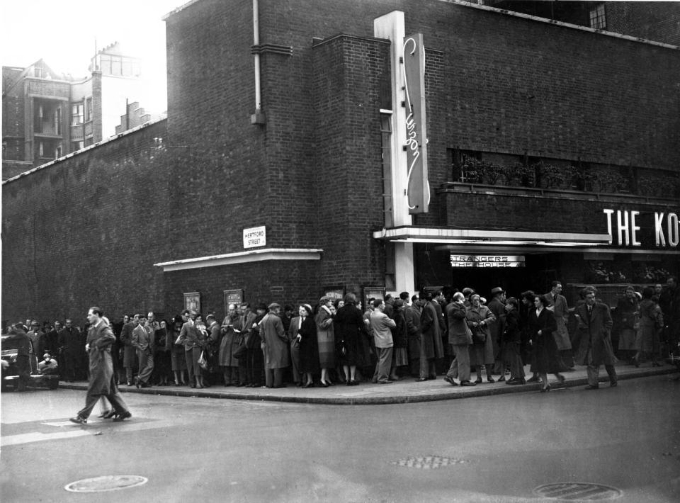 Black and white photo of a queue of people outside the Curzon Mayfair cinema in the 1950s.