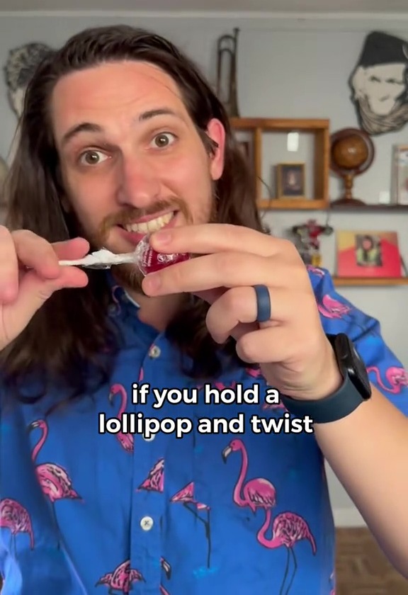 Man holding and twisting a lollipop.