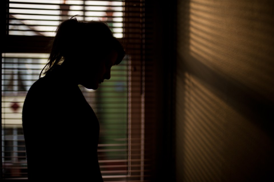 Silhouette of a woman standing at a window.