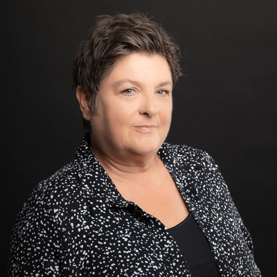 a woman with short hair is wearing a black and white polka dot shirt