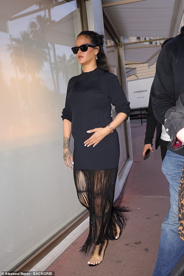 Rihanna cradled her baby bump as she stepped out on Cannes' famous Croisette boulevard to visit the Boutique Messika on Wednesday