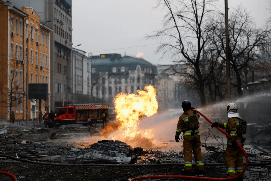 Firefighters battling a large fire in a city street.