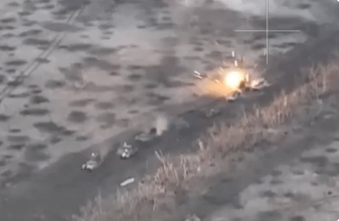 Aerial view of a column of tanks being destroyed by an explosion.