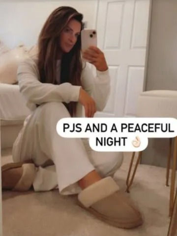 Woman in pajamas and slippers taking a selfie.