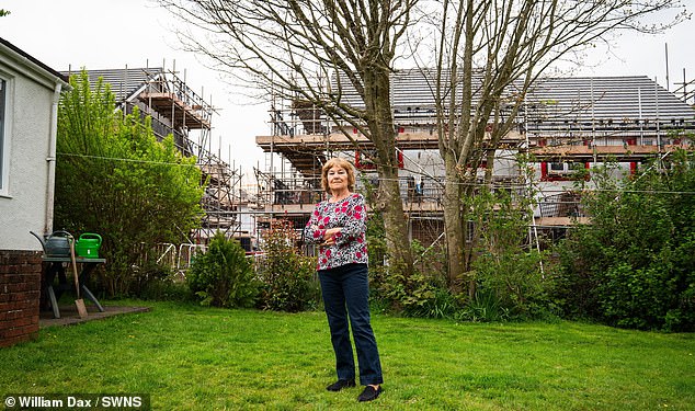 Martine Le Barth outside her home, with the new housing development behind her in South Molton Devon