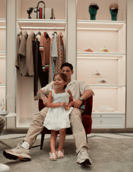 A man and young girl sitting in a chair in a store.