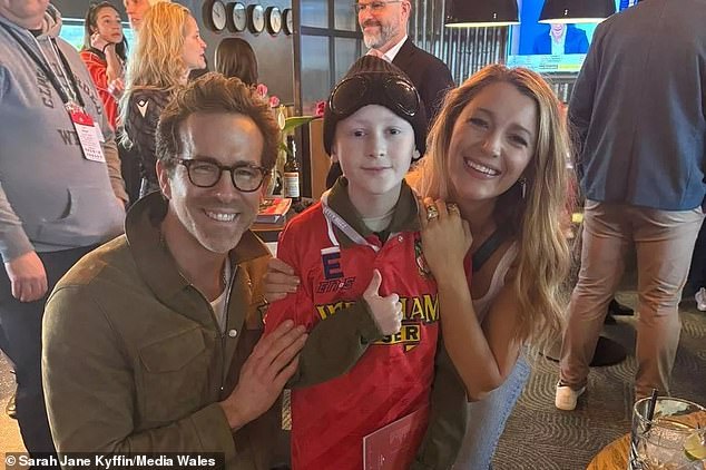 Wrexham co-owners Ryan Reynolds and Rob McElhenney have stunned a local charity fundraiser with a surprise donation to help young people living with cancer. Pictured: Ryan Reynolds and his wife Blake Lively with Wrexham fan Archie White