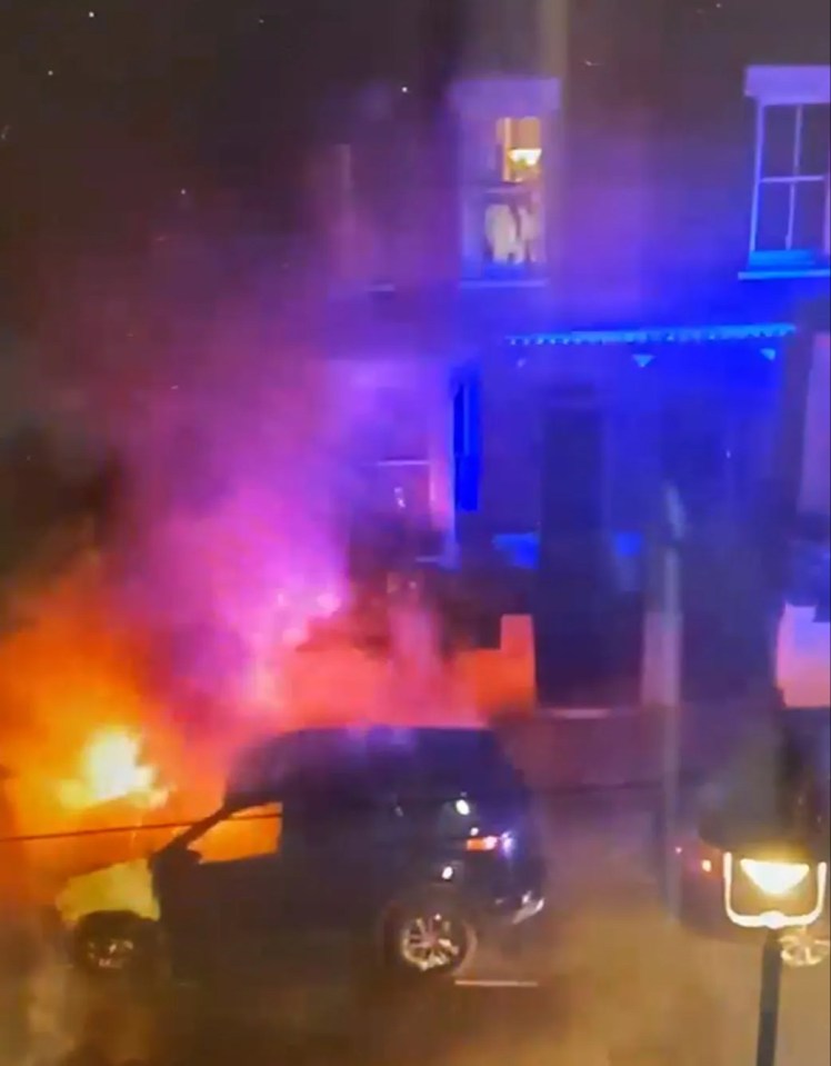 Screengrab of firefighters extinguishing a burning car.