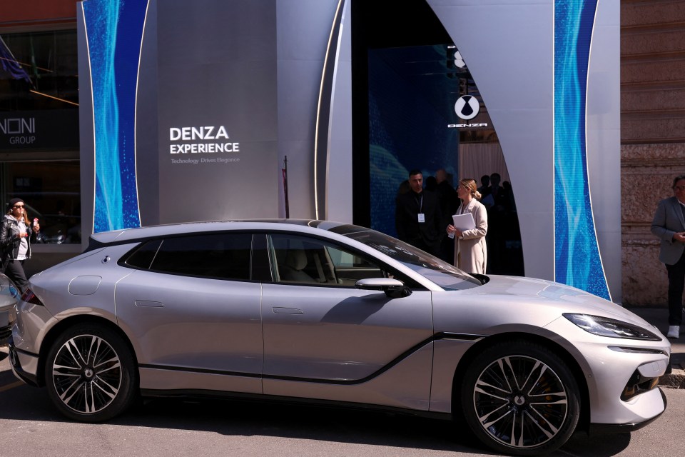 Silver Denza Z9GT car on display at a launch event.