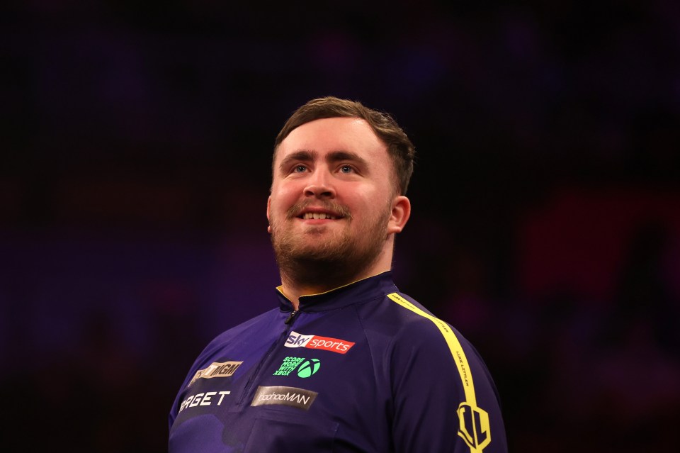 Luke Littler of England reacts during a darts match.