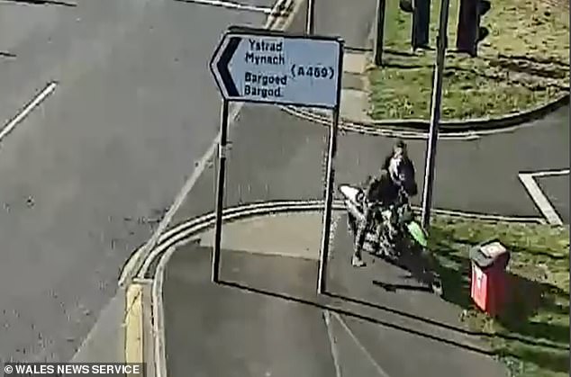 This is the shocking moment a reckless biker dragged a brave police officer across a road as he tried to arrest him