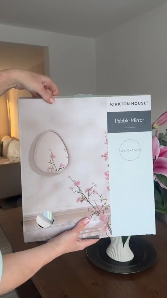 Person holding a Kirkton House Pebble Mirror box.