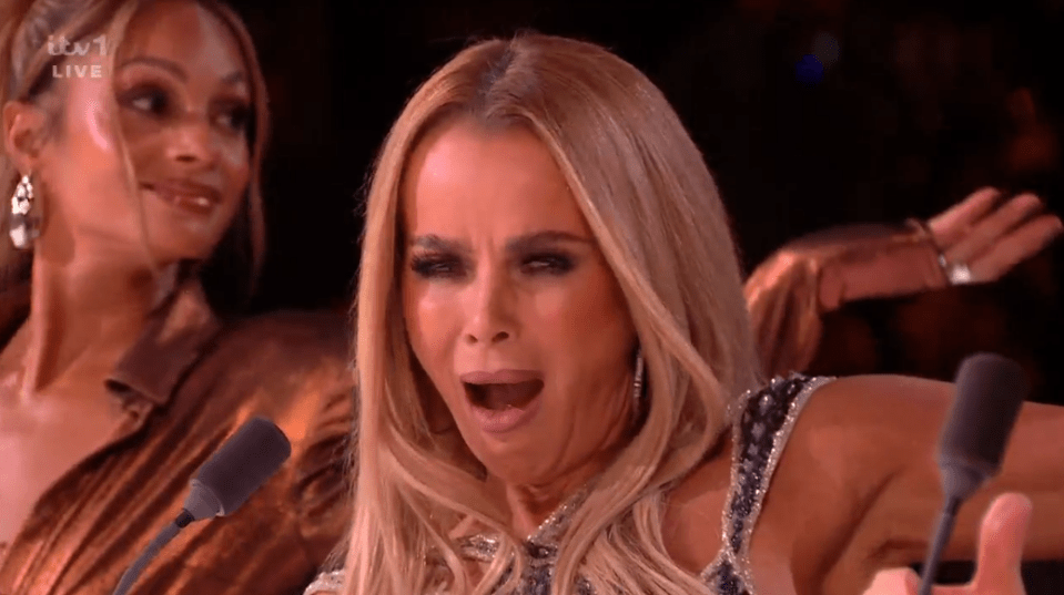 Screenshot of a woman with blonde hair yawning at a microphone, another woman is visible in the background.