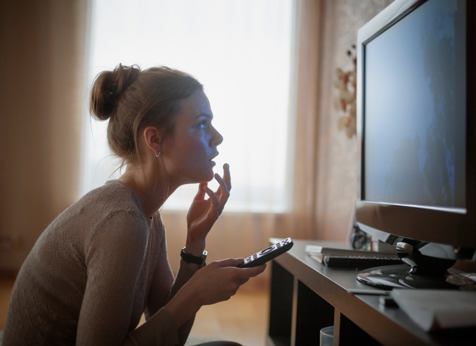 Woman sitting on the floor watching TV.