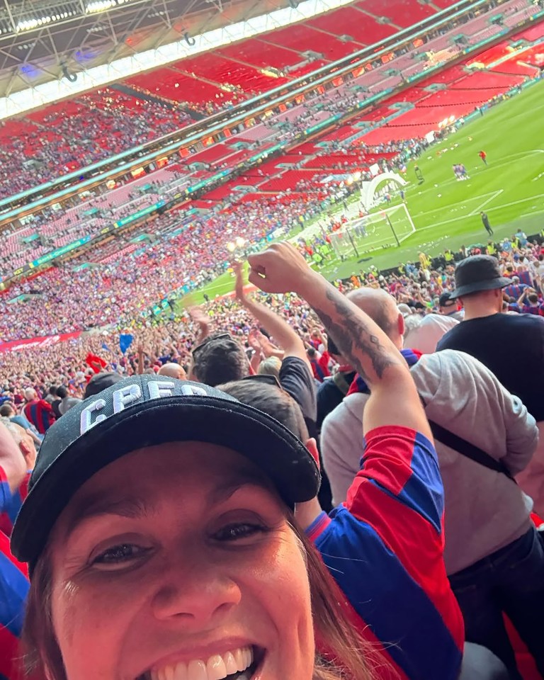 A jubilant fan at a Crystal Palace FA Cup victory celebration in a packed stadium.
