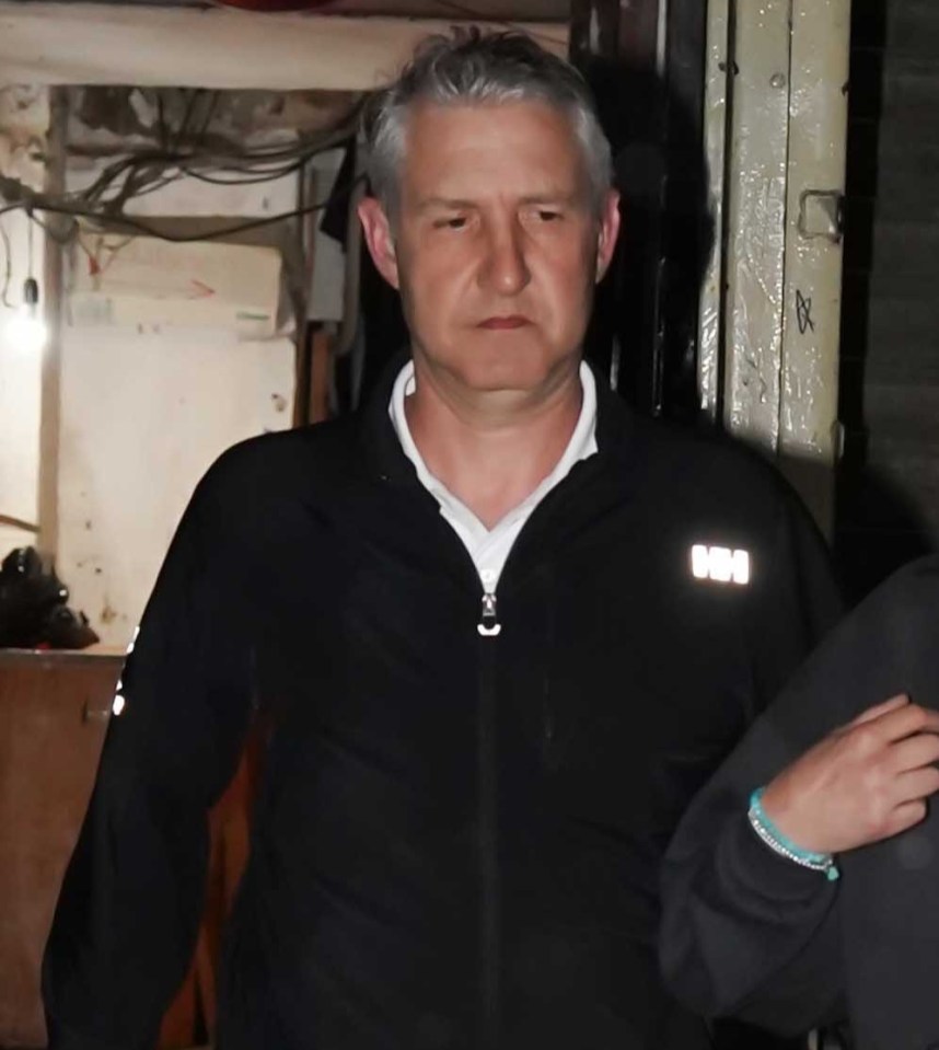 A man in a black zip-up jacket leaving a lawyers office.