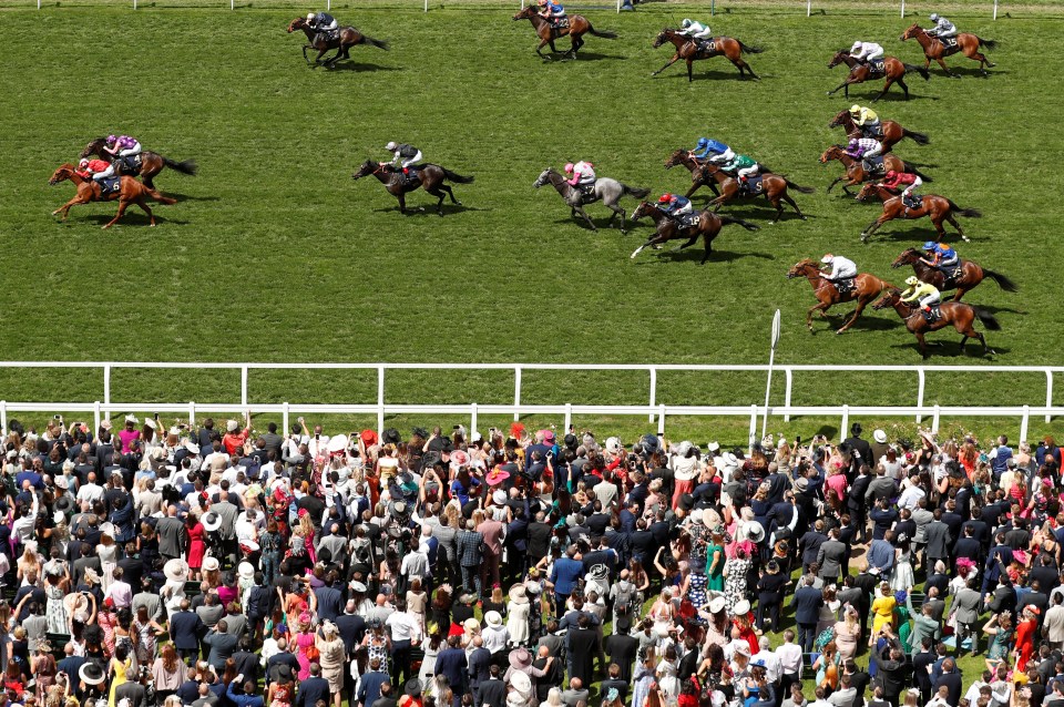 Horse race at Ascot Racecourse with spectators.