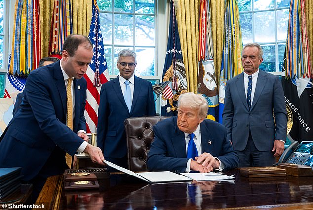 Donald Trump is pictured above preparing to sign the executive order on gain-of-function research. He is flanked by his secretary for health Robert F. Kennedy Junior, the head of the NIH, Dr Jay Bhattacharya, and the head of the Centers for Medicare and Medicaid Services, Dr Mehmet Oz. White House Secretary Will Scharf is shown handing the President the order