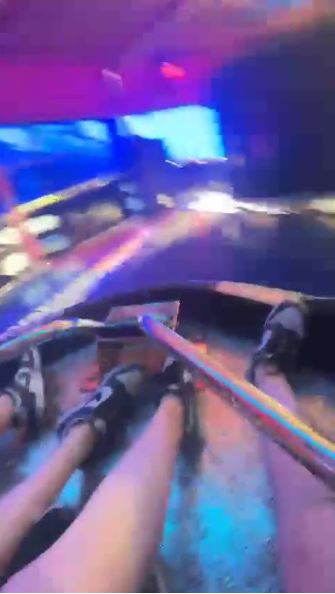 Legs and feet of people on a spinning carnival ride.