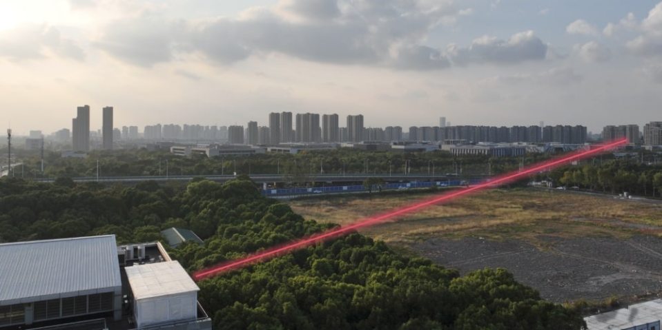 Infrared laser beams targeting a distant building.