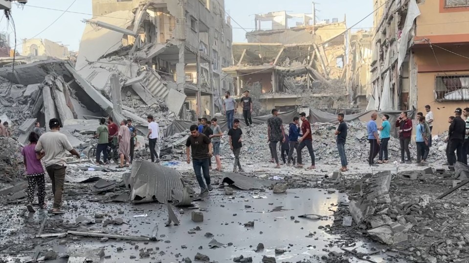 Destruction and people surveying the damage in Gaza City after Israeli airstrikes.
