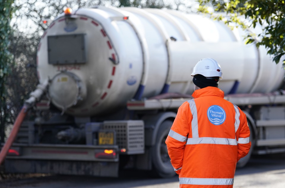 Thames Water worker standing in front of a sewage tanker.