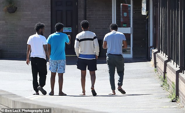A group of men stroll through the hotel car park on a sunny midweek afternoon