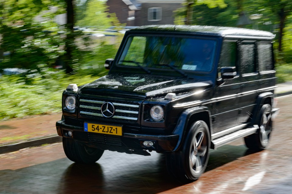 Black Mercedes-Benz G-Class driving in the rain.