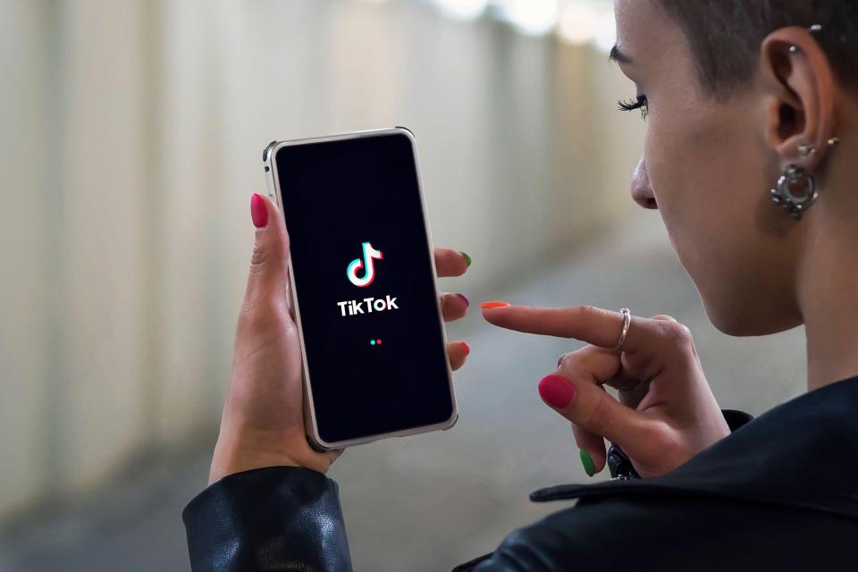 Woman using TikTok app on her phone.