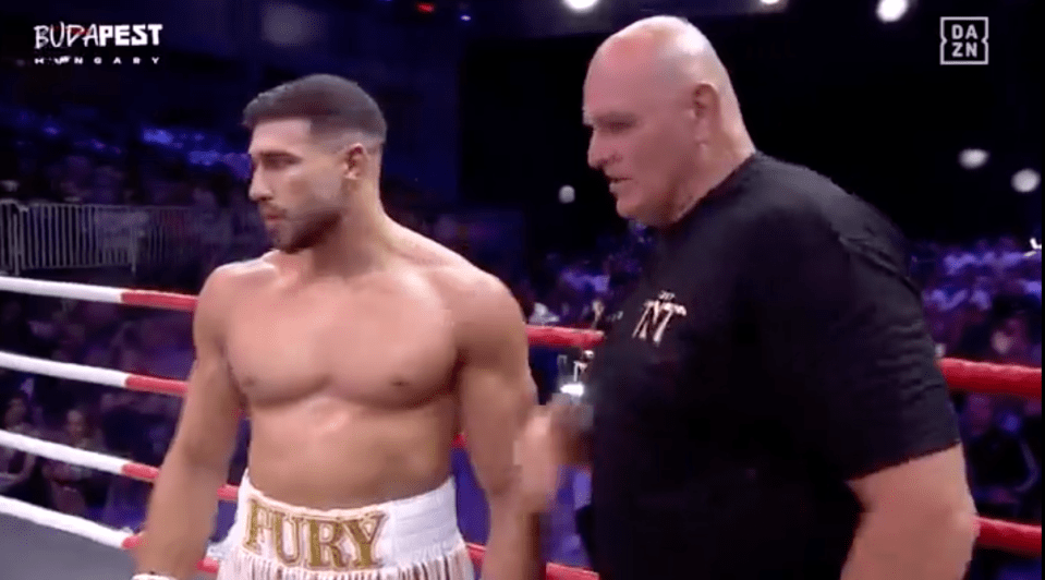 Boxer and trainer in boxing ring.