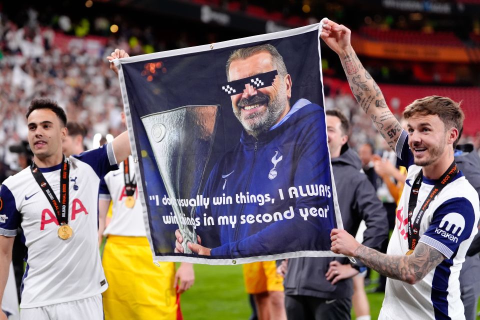 Tottenham Hotspur players holding a banner celebrating their manager's win.