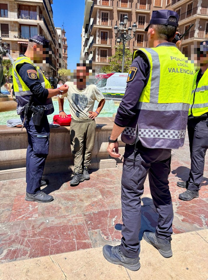Police arresting a homeless man in Valencia, Spain.