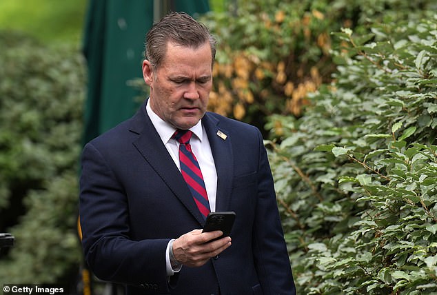 National Security Adviser Michael Waltz looks at his phone as he prepares for a TV interview at the White House on Thursday immediately before his firing