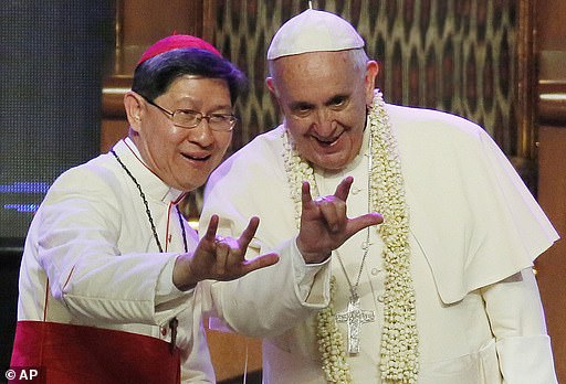 The two frontrunner's to replace Pope Francis have been accused of mishandling child sexual abuse claims. Italian cardinal Pietro Parolin and Filipino cardinal Luis Antonio Tagle, cannot be trusted to protect children from abuse, according to a campaign group. Pictured: Filipino Cardinal Luis Antonio Tagle, left, shows Pope Francis how to give the popular hand sign for 'I love you' at the Mall of Asia arena in Manila