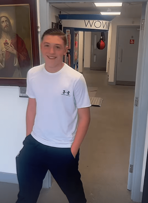 Teenager standing in a hallway.